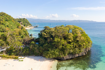 Obraz premium Rocky islands with a white sandy beach, view from above. The coast of the island of Boracay. Tropical trees on the rocks near the water.