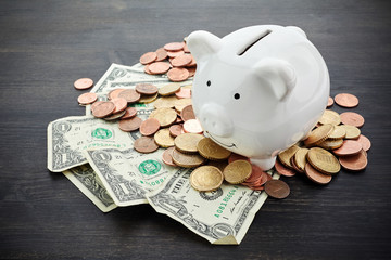 piggy bank with money on dark wooden background