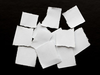 scraps of white paper on a black background