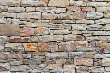 Fragment of a wall from a natural stone at daylight