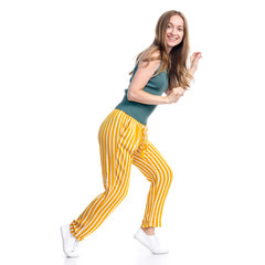 Woman in yellow pants smiling happiness goes sneaks sneak up on white background isolation