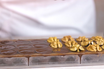 Preparing homemade chocolate candies with walnuts at home.