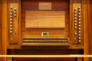 Fototapeta na wymiar Pipe organ seat with keyboard, timbres and music stand.