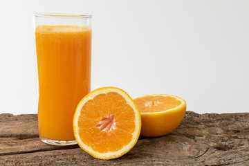 Un vaso de zumo de naranja sobre una madera rustica