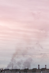 vertical banner of industrial chimneys on a cloudy sky background with heavy smoke causing air pollution as environmental problem