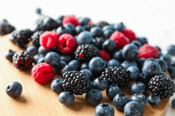 Berries and cutting board on white background, closeup and space for text