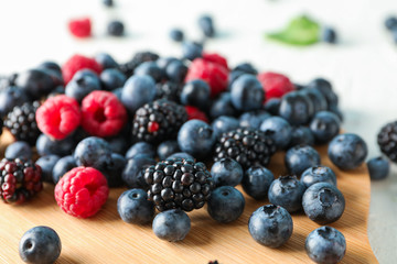 Berries and cutting board on white background, closeup and space for text