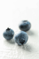 Blueberries on white cement background, closeup and space for text