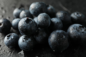 Blueberries on black cement background with drops,  space for text