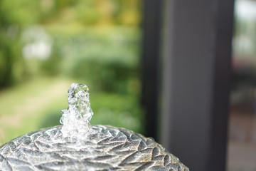 A small fountain with a garden decoration. 