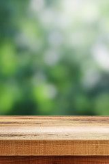 Blurred abstract green bokeh and wooden table background.