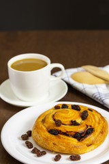 Close up custard raisin danish bread and coffee cup