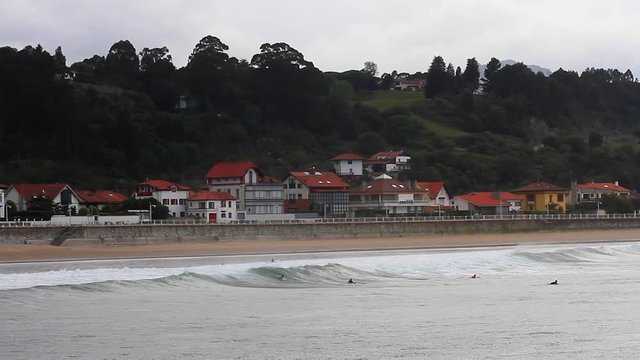 Surfistas en clases de surf cerca de la playa con olas bajas . Ribadesella