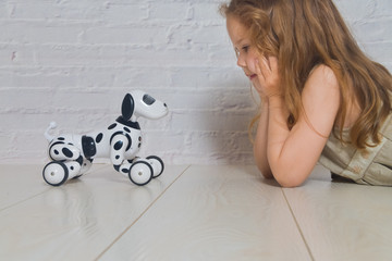 the baby girl playing takes care of dog robot