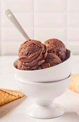 Chocolate ice cream bowl and cones on the white surface. - 276556585