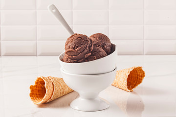 Chocolate ice cream bowl and cones on the white surface. - 276556721