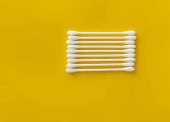 White cotton buds in extreme close up on yellow background