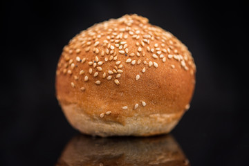 Bun with sesame seeds on a black background.