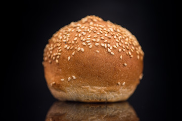 Bun with sesame seeds on a black background.