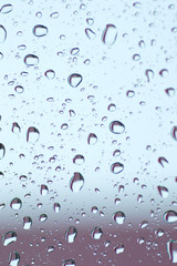 Water drops of rain on blue and brown glass background