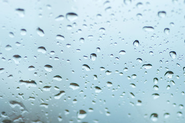 Water drops of rain on blue glass background