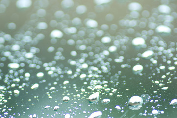 Water drops of rain on green glass background