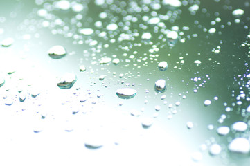 Water drops of rain on green glass background