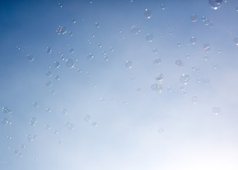 Soap bubbles fly in the blue sky