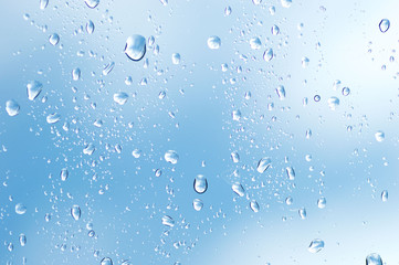 Water drops of rain on blue glass background