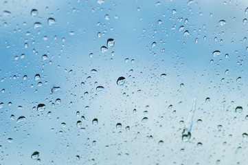 Water drops of rain on blue glass background