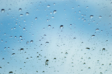 Water drops of rain on blue glass background