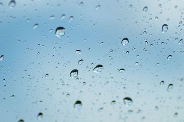 Water drops of rain on blue glass background