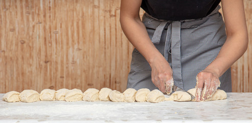 The hostess cuts the dough in the kitchen