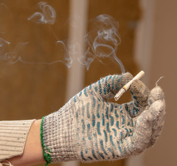 Cigarette in the hand of a worker at a construction site