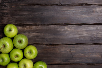 Green apples on wood background with corner