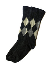 Isolated textured plaids and checks rhomb pattern black gray and beige color pair of two cotton material sock socks laying laid flat on white clear solid background surface 