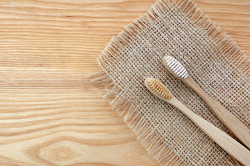 Zero waste concept. Bamboo toothbrush on wooden background. Plastic free essentials, teeth care.