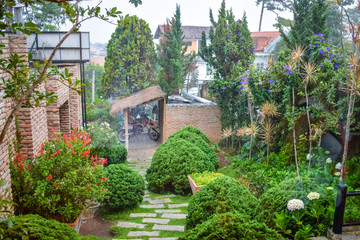 Naklejka premium Tropical rain in the yard with green bushes and a motorcycle under a canopy