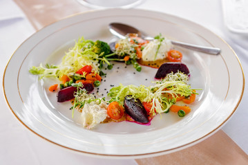 Served table at the banquet. Salad with beets and cherry tomatoes with cream cheese