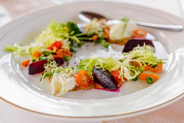 Served table at the banquet. Salad with beets and cherry tomatoes with cream cheese