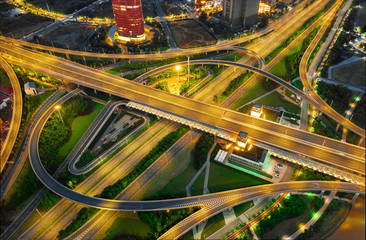 Fototapeta na wymiar Aerial drone night shot of multilevel illuminated ring highway road junction leading to the sea