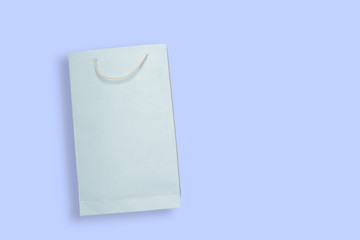 Light blue color shopping paper bag on Blue color background with copy space.