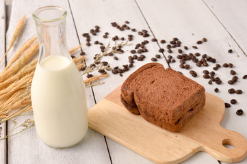 Bread and milk with coffee bean for breakfast on wooden background