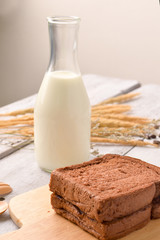 Bread and milk with coffee bean for breakfast on wooden background