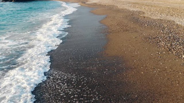 Sandy beach with waves beating againt it. Aerial view.