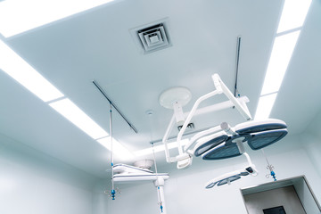 Working surgeon on the background of surgical lamp.