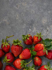 Fresh red strawberries on a gray background with copy space. Top view.