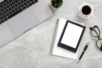 Office desk table with laptop computer, blank copy space mockup screen tablet, succulent plant, cup of coffee, glasses and supplies. Top view with copy space, flat lay. Feminine workspace concept.