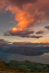 Atardecer con cielo naranja y un lago forman el paisaje