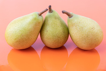 Set of isolated green pears on an orange background - Freshly harvested pears - Ripe and sweet pears